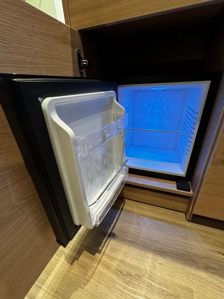 Hotelkühlschrank mit offener Tür und blauem Innenlicht