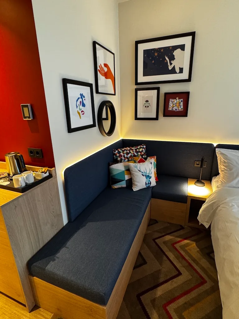 Hotelzimmer mit gemütlicher Ecke und dekorativen Bildern an der Wand