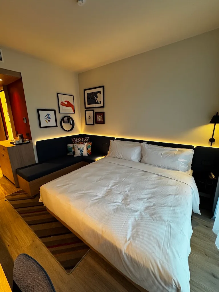Hotelzimmer mit Doppelbett und dekorativen Bildern an der Wand