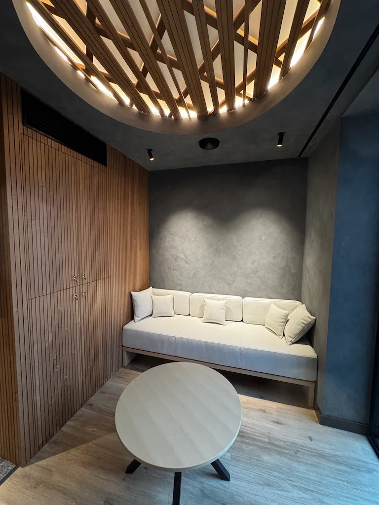 Hotelzimmer mit Holzvertäfelung und beleuchteter Decke