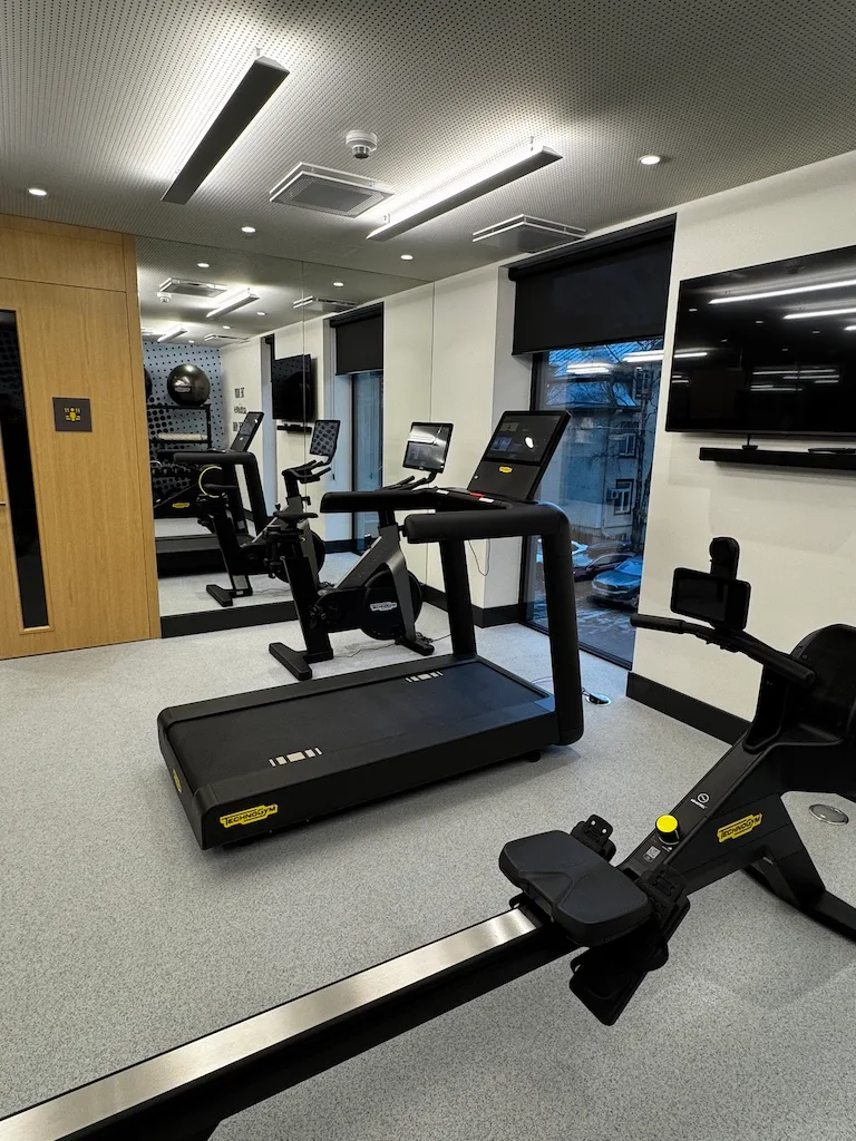 Fitnessraum mit Laufbändern, Rudergeräten und Fahrrädern