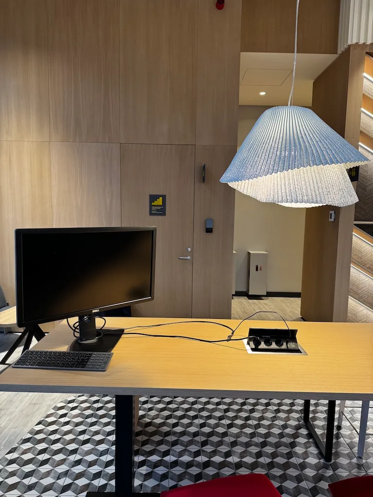 Hotelzimmer mit Monitor und Steckdose im Tisch