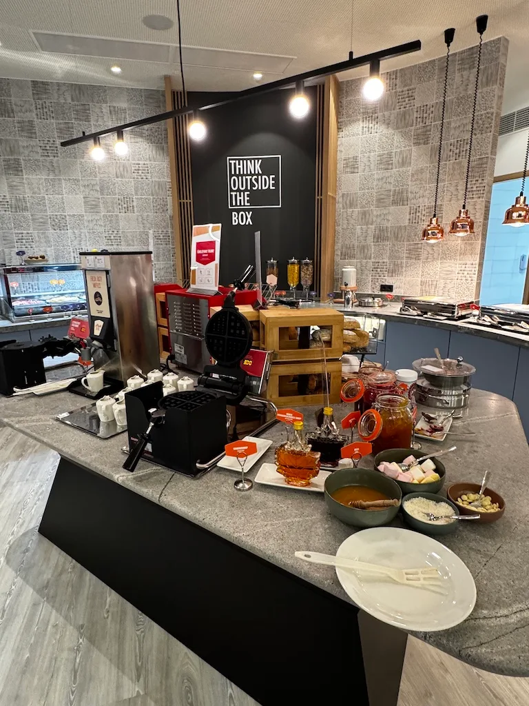 Frühstücksbuffet mit Waffeleisen und verschiedenen Beilagen