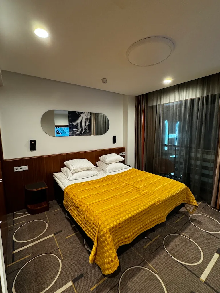 Hotelzimmer mit Doppelbett und gelber Decke