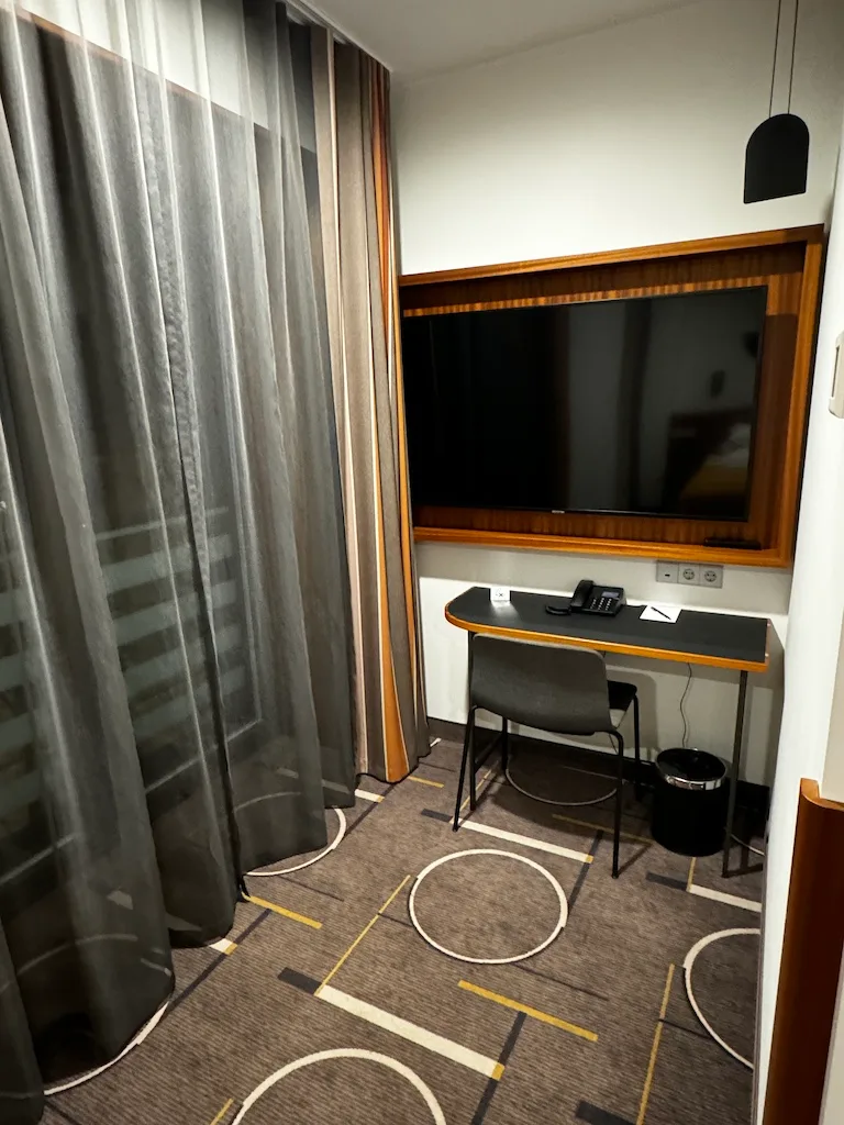 Hotelzimmer mit Schreibtisch und Fernseher