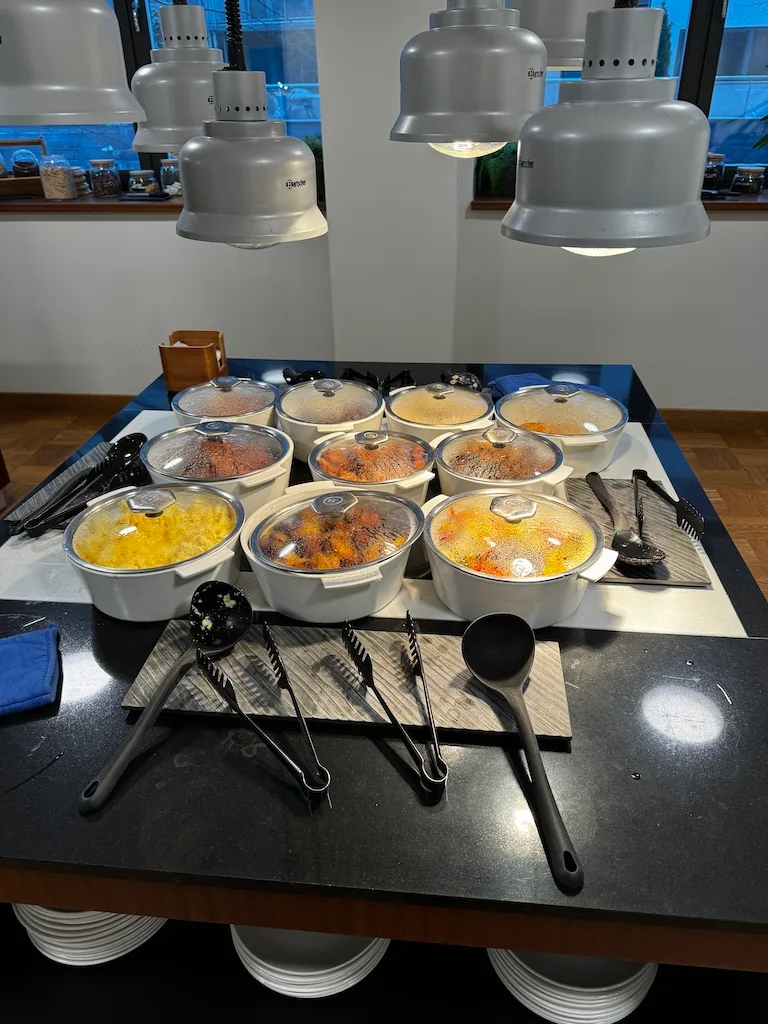 Buffet mit mehreren Schüsseln und Kochutensilien auf einem Tisch