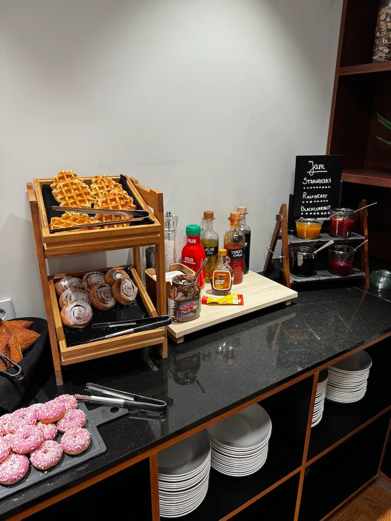 Frühstückstablett mit Waffeln, Käsekuchen und Marmeladen
