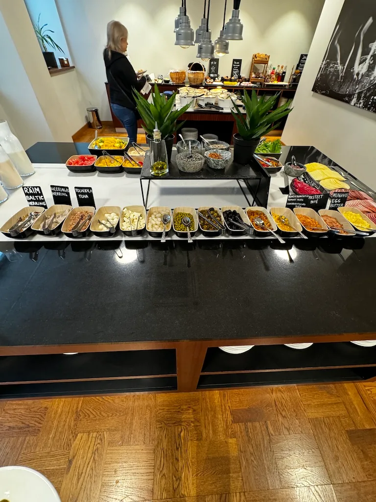 Frühstücksbuffet mit verschiedenen Salaten und Beilagen auf schwarzem Tisch