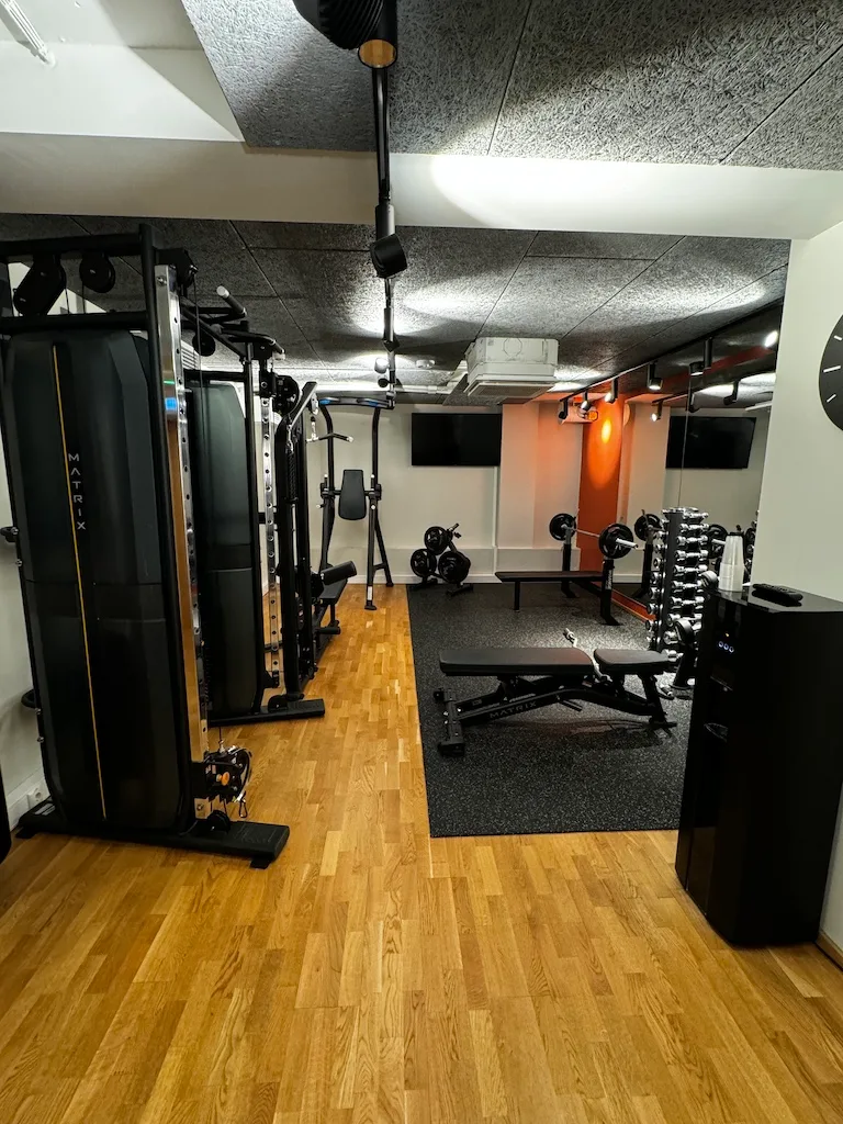 Fitnessraum mit Trainingsgeräten und Bodenmatte