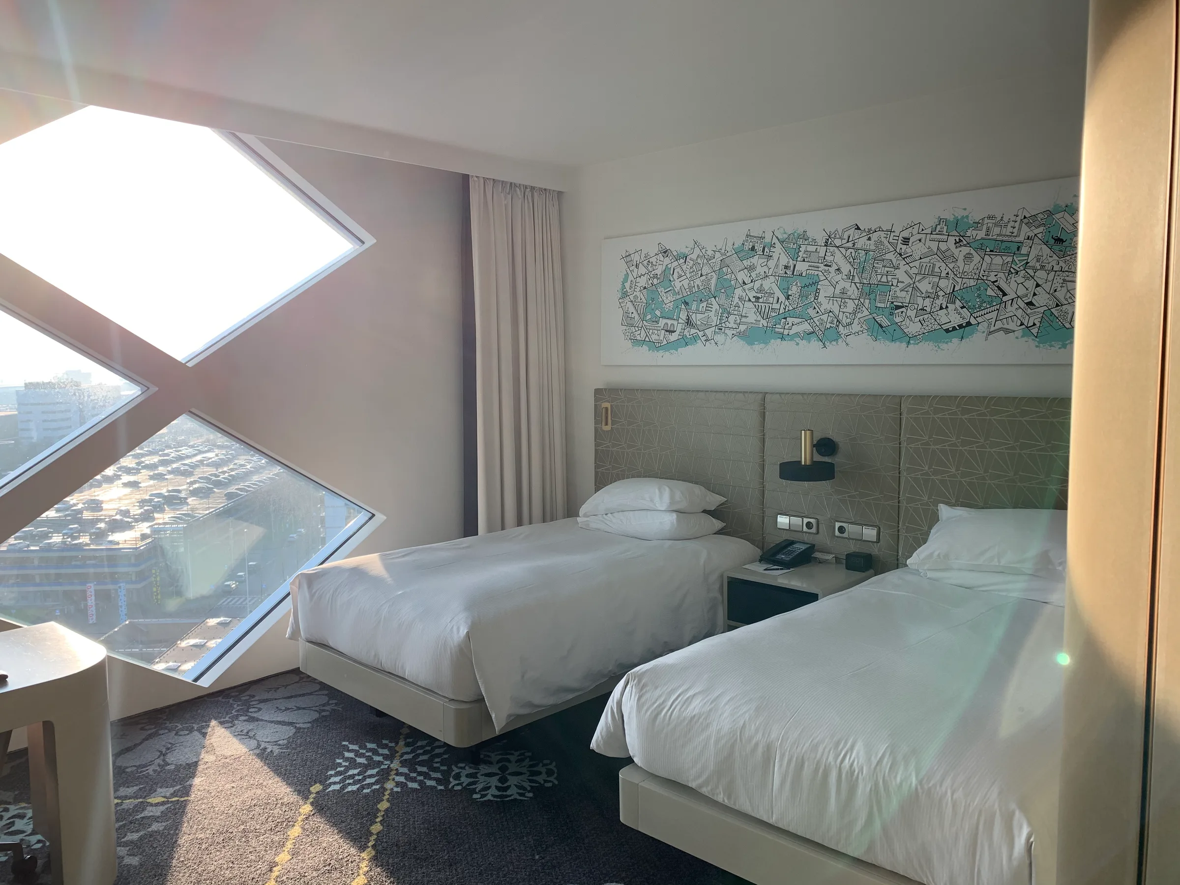 Doppelbett im Hotelzimmer mit Panoramafenster