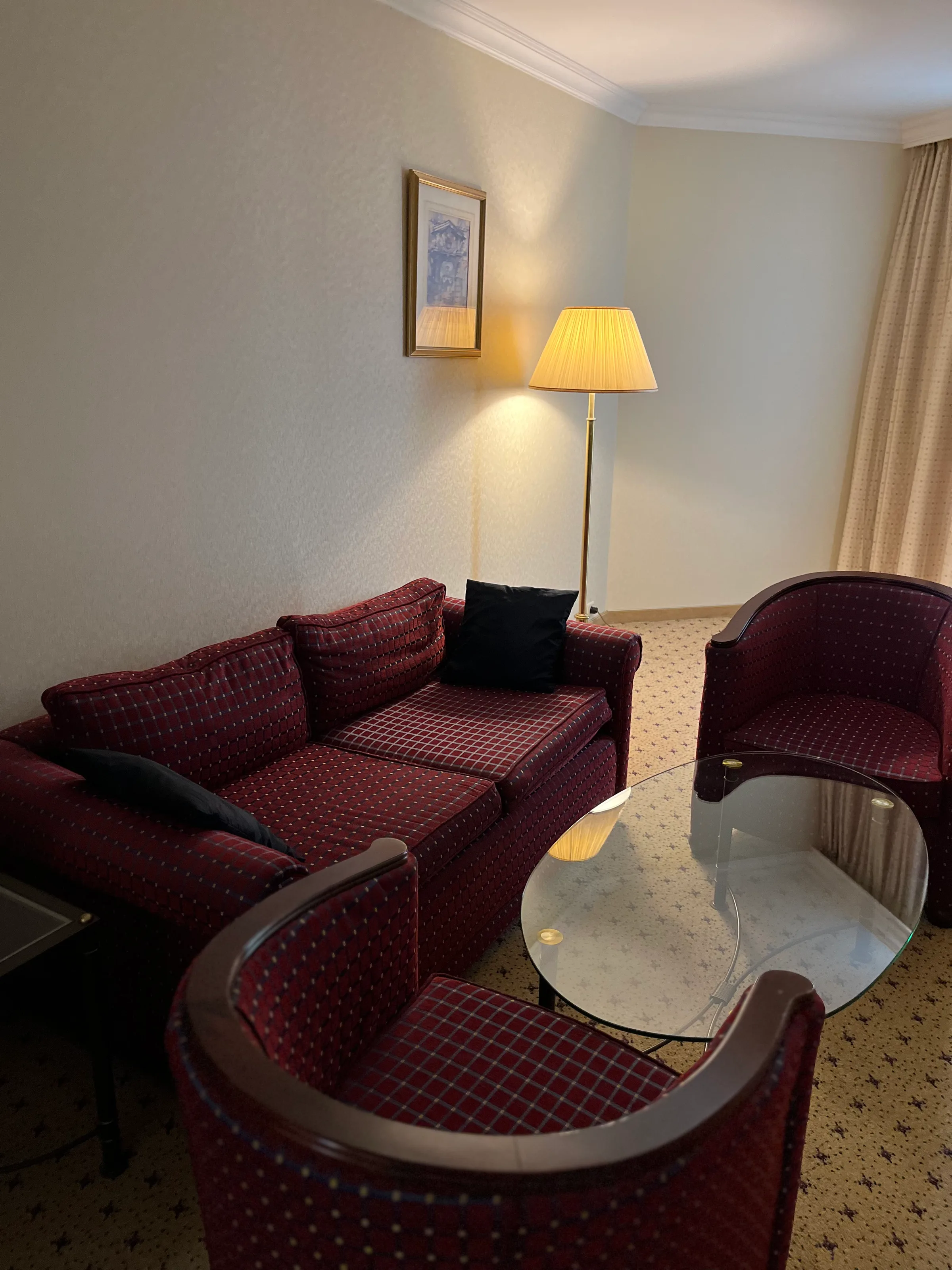 Hotelzimmer mit rotem Sofa und Sesseln
