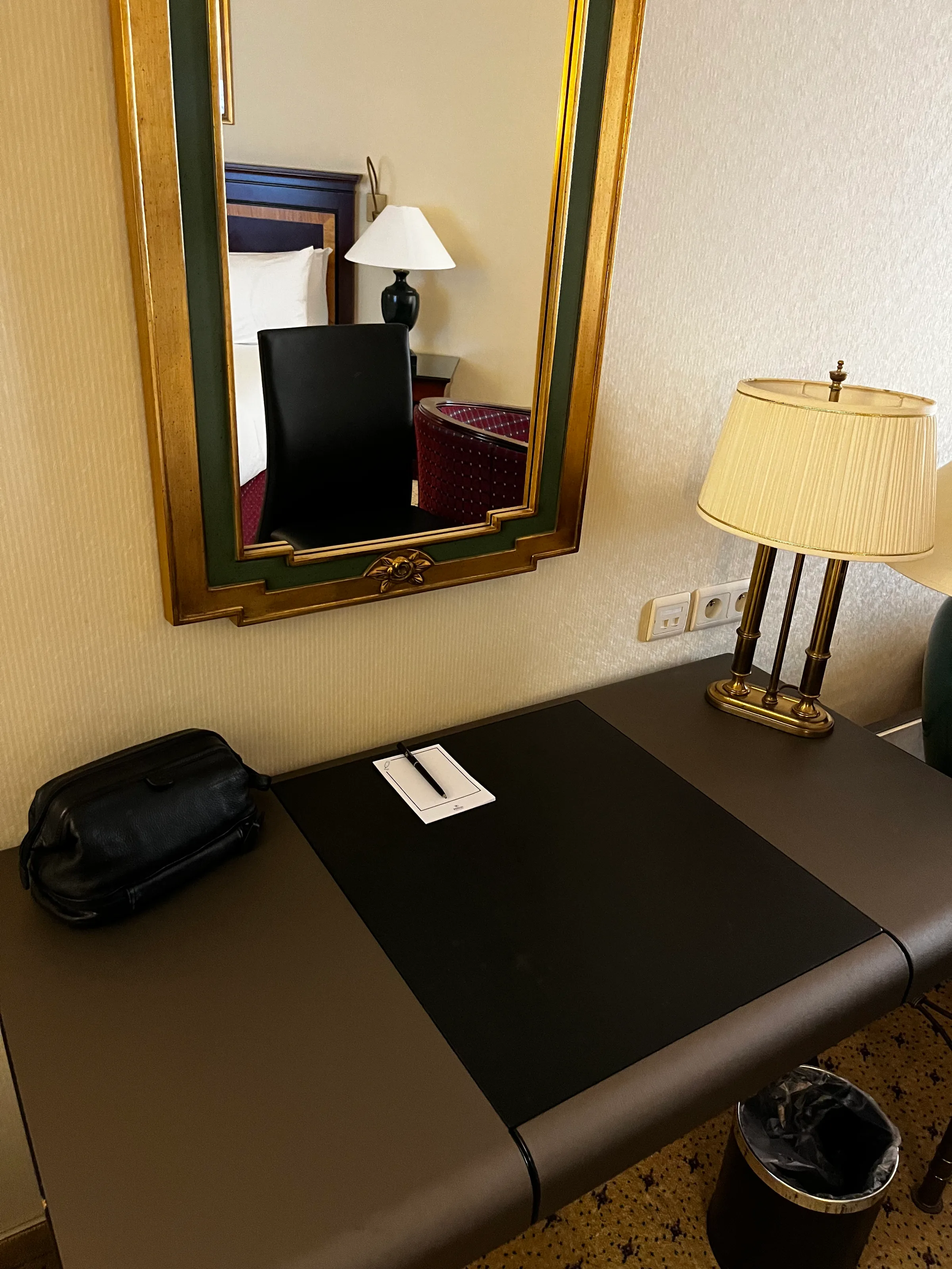 Hotelzimmer mit Schreibtisch, Lampe und Spiegel