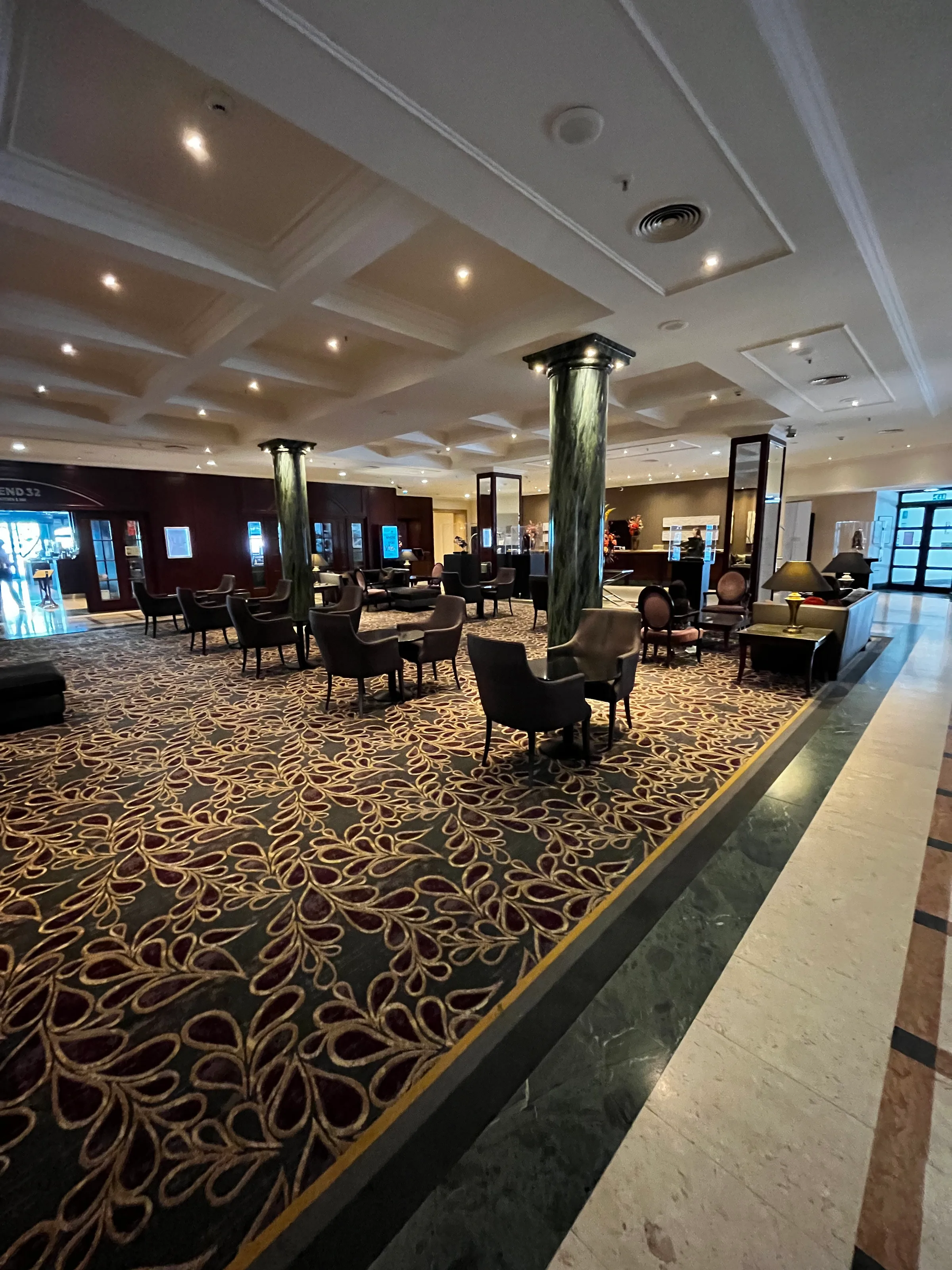 Hotellobby mit Sesseln und Teppich im traditionellen Stil