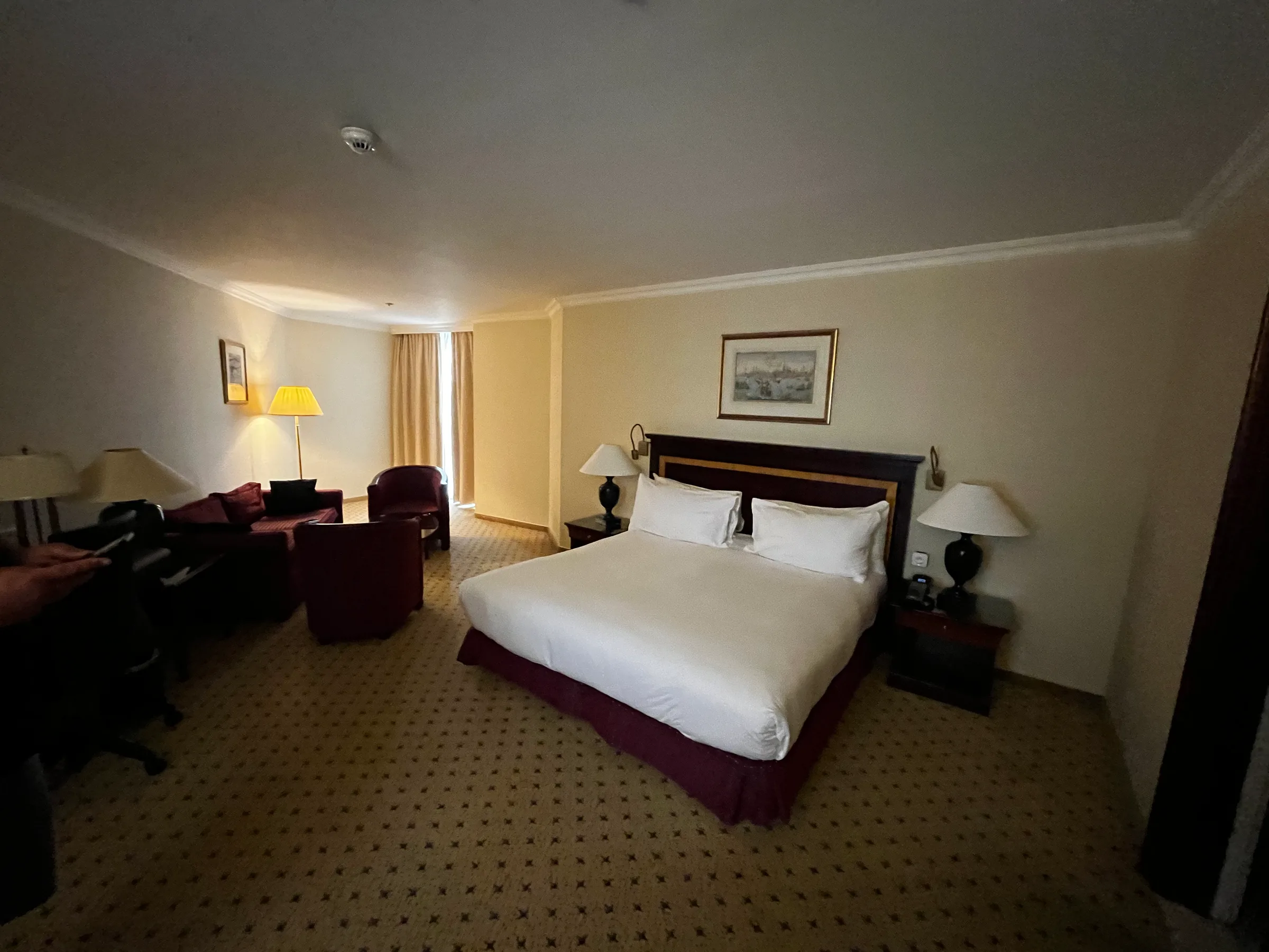 Hotelzimmer mit Doppelbett und Tagesdecke in Grautönen
