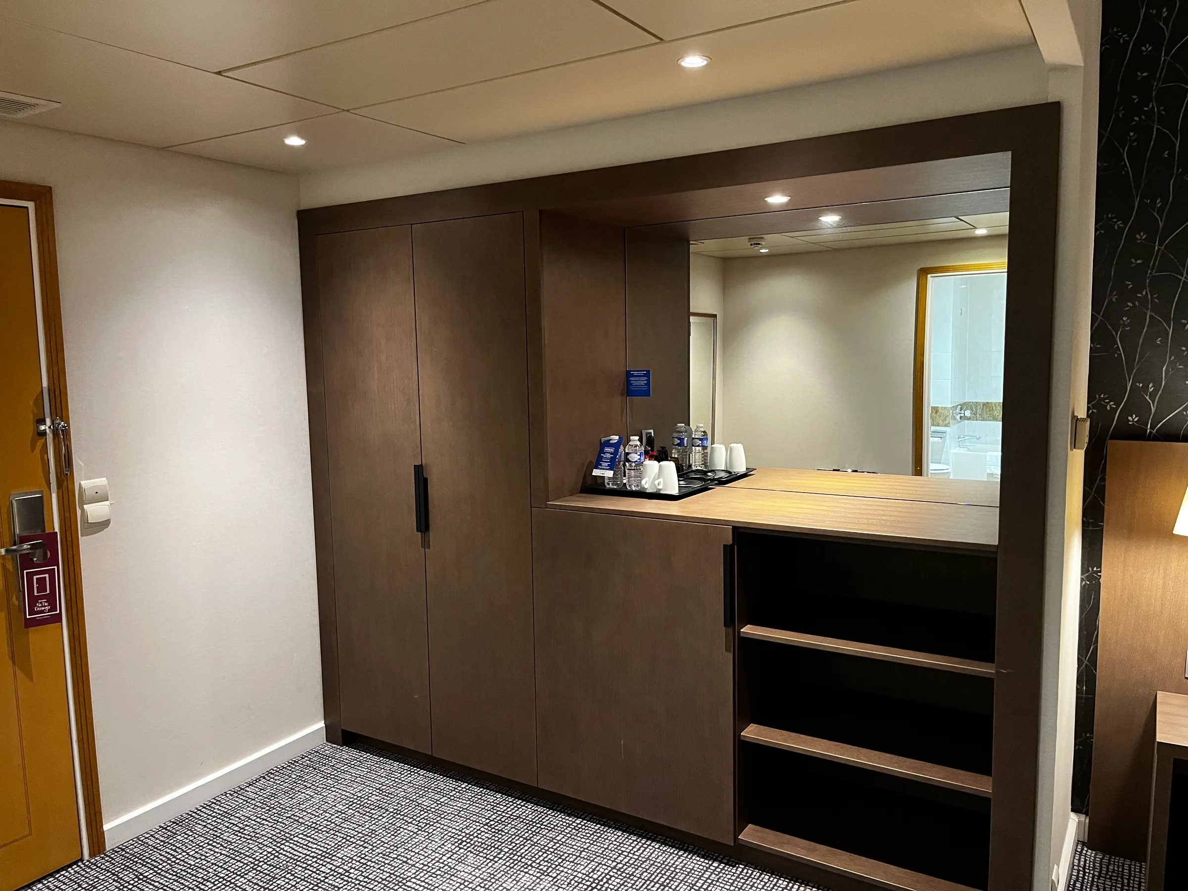 Hotelzimmer mit Holzschrank und Spiegeltür