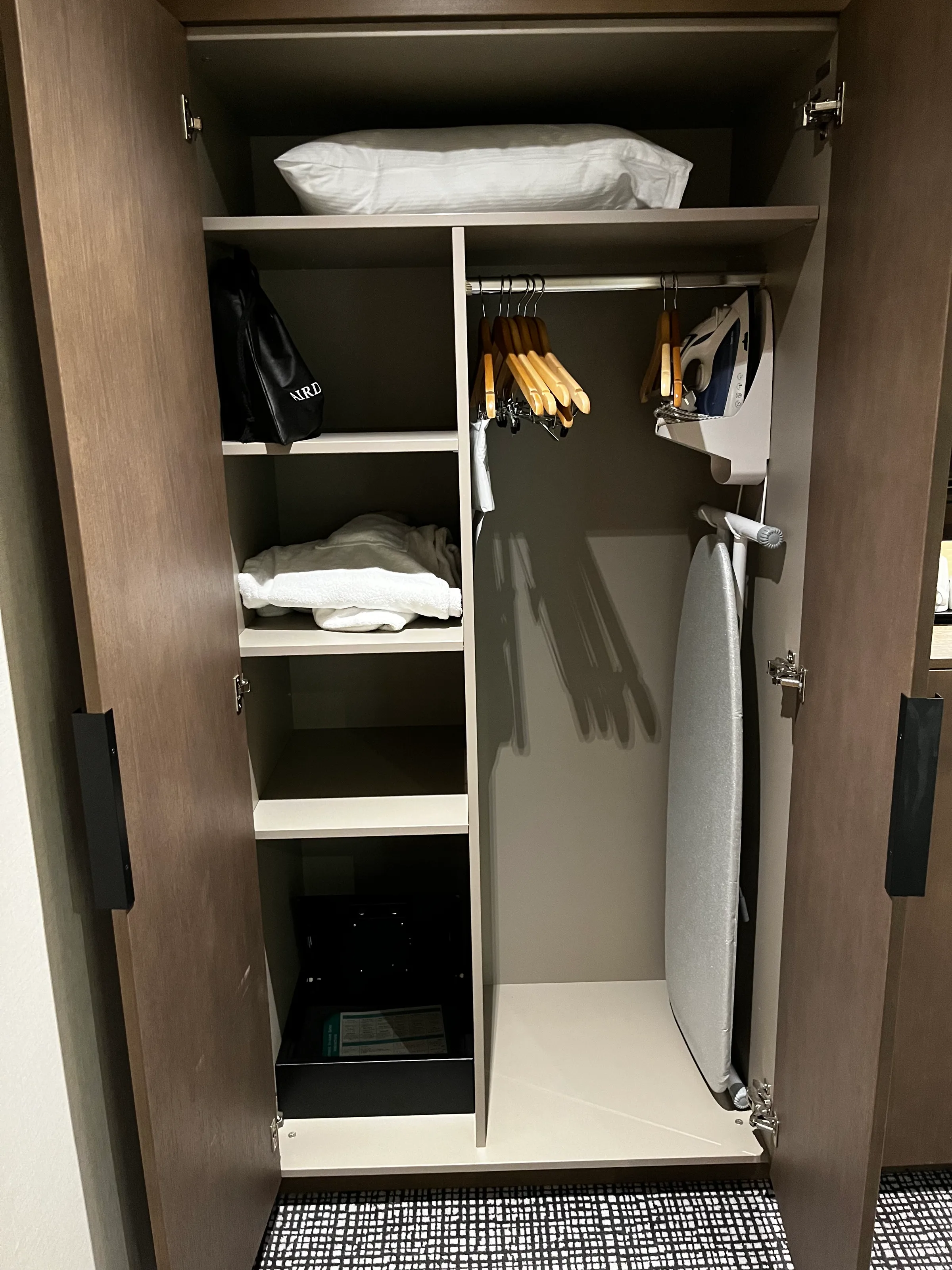 Hotelgarderobe mit Kleiderbügeln und Bügeleisen