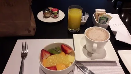 Frühstückstablett mit Obstsalat, Kaffee und Orangensaft