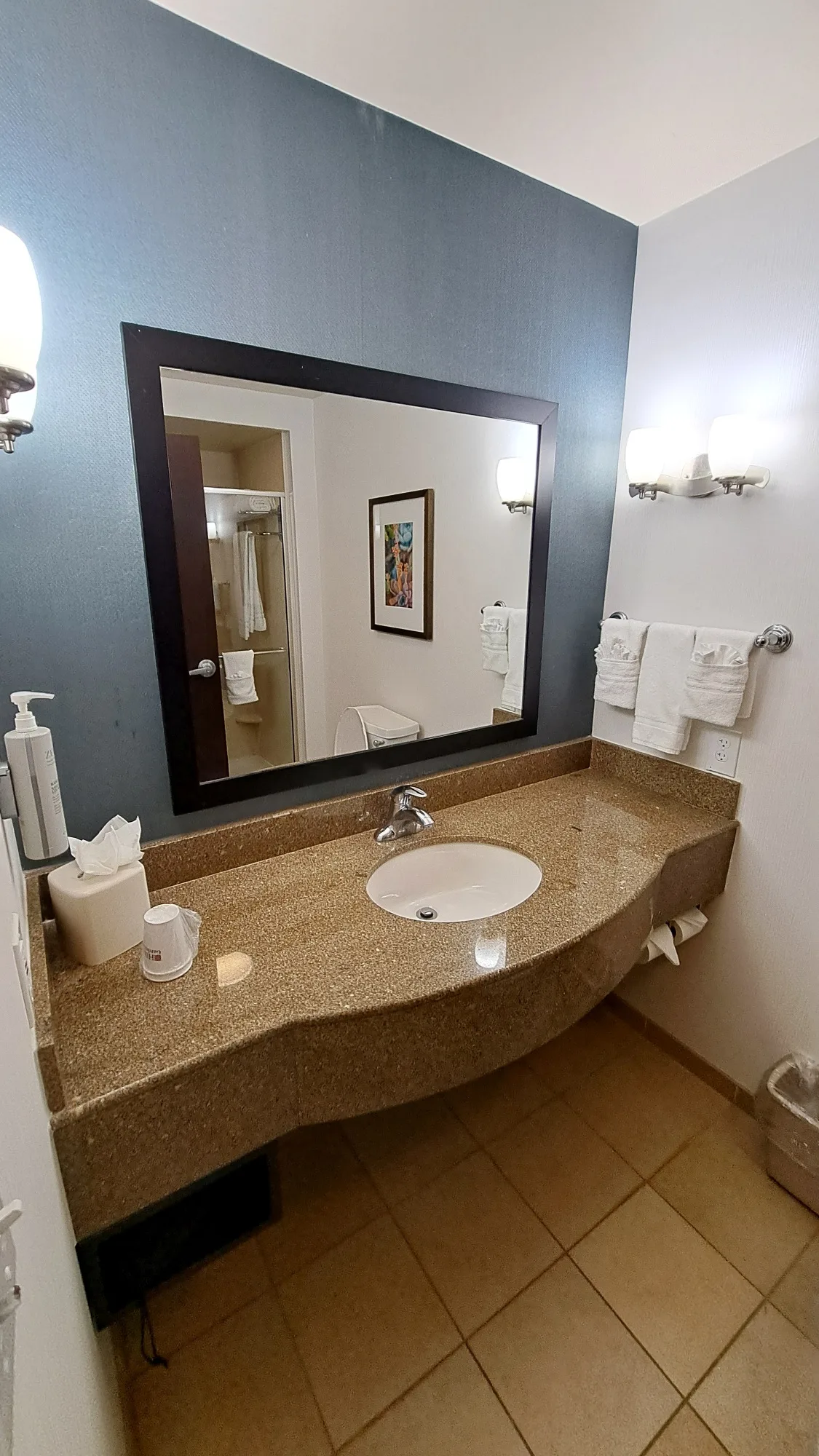 Hotelbadezimmer mit Waschbecken, Spiegel und Handtüchern