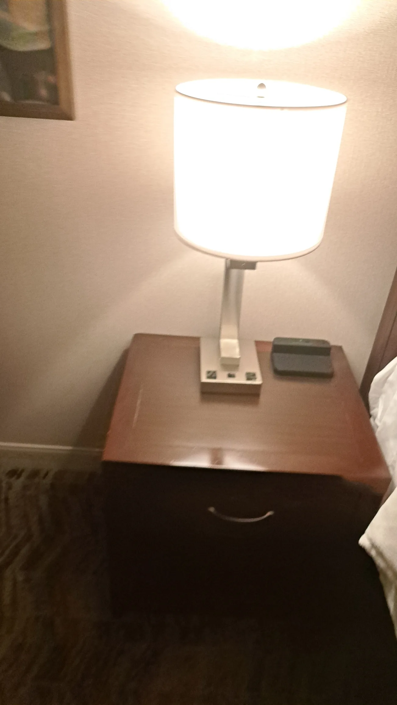 Nachtisch mit Lampe und Telefon auf Holztisch