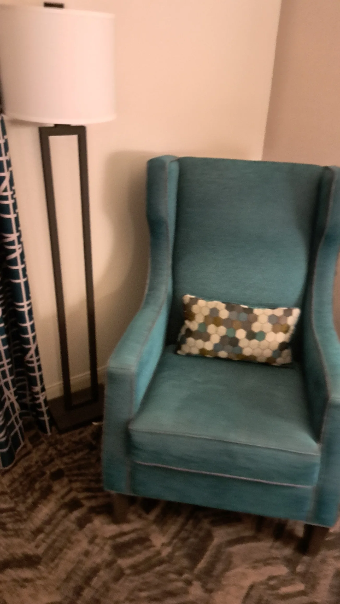 Blauer Sessel mit Kissen in geometrischem Muster