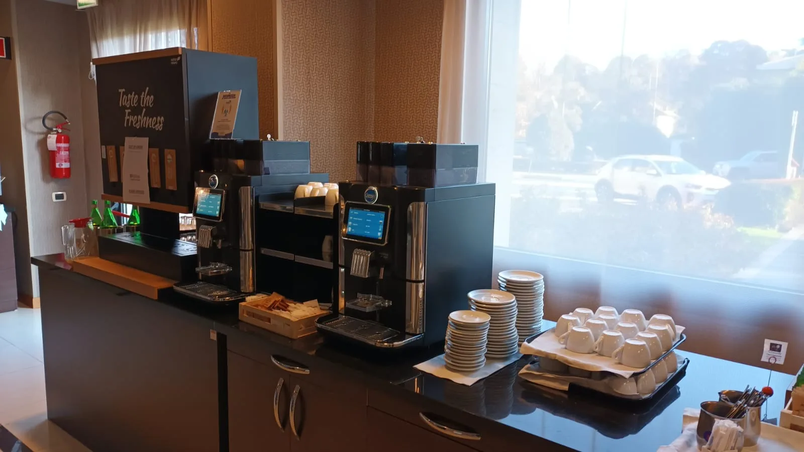 Kaffeeautomat und Geschirr im Frühstücksbereich