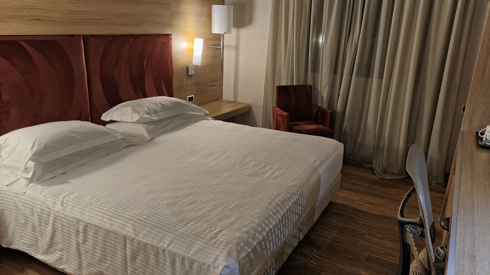 Hotelzimmer mit Doppelbett und Nachttischlampe