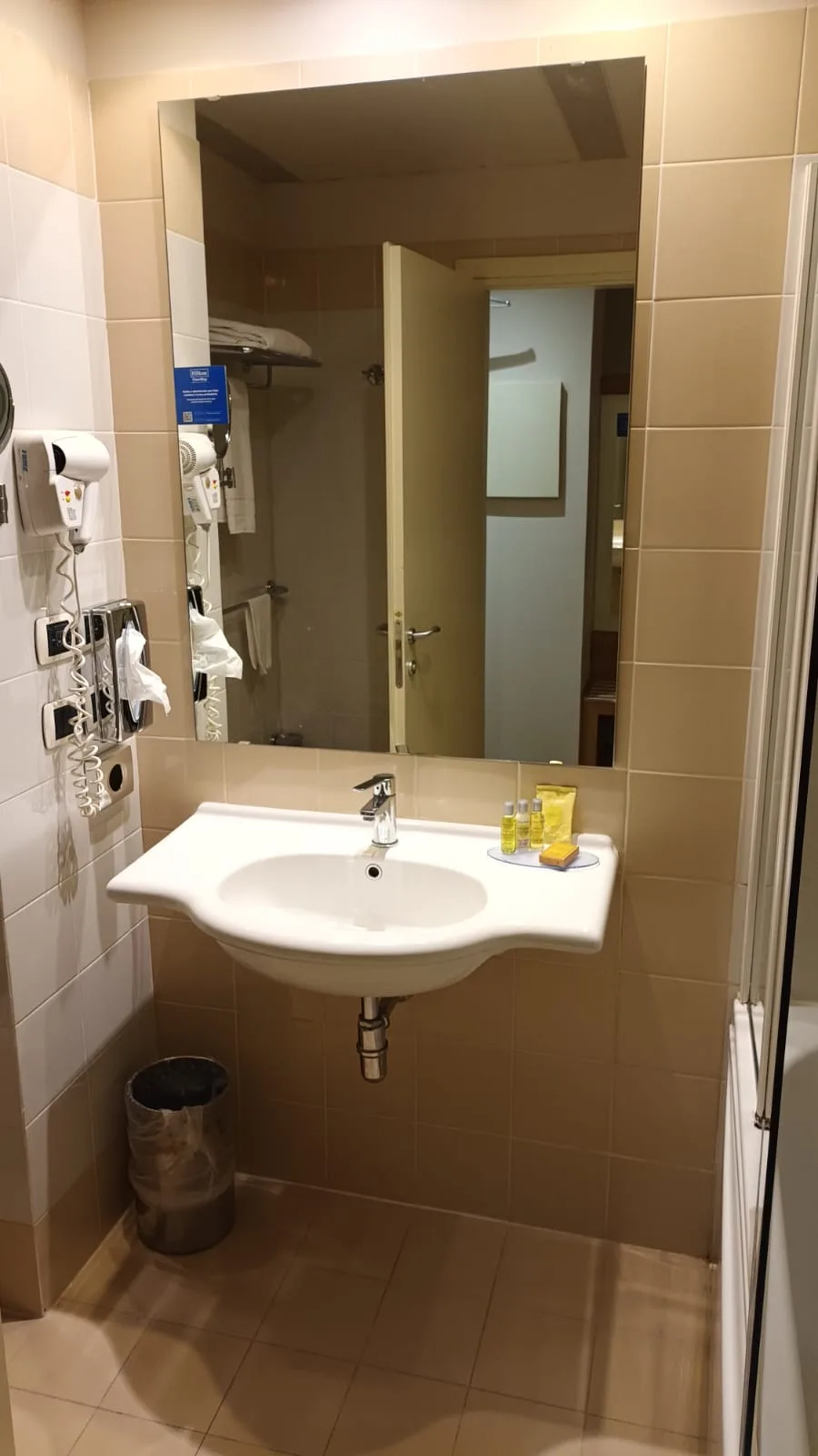 Hotelbadezimmer mit Waschbecken, Spiegel und Handtüchern