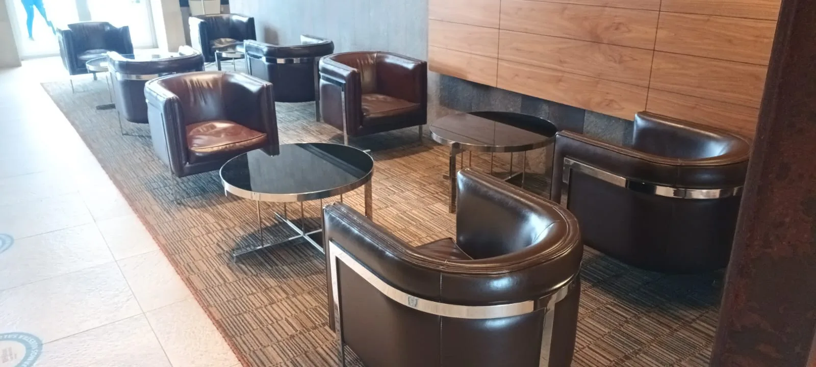 Lounge mit Ledersesseln und runden Tischen