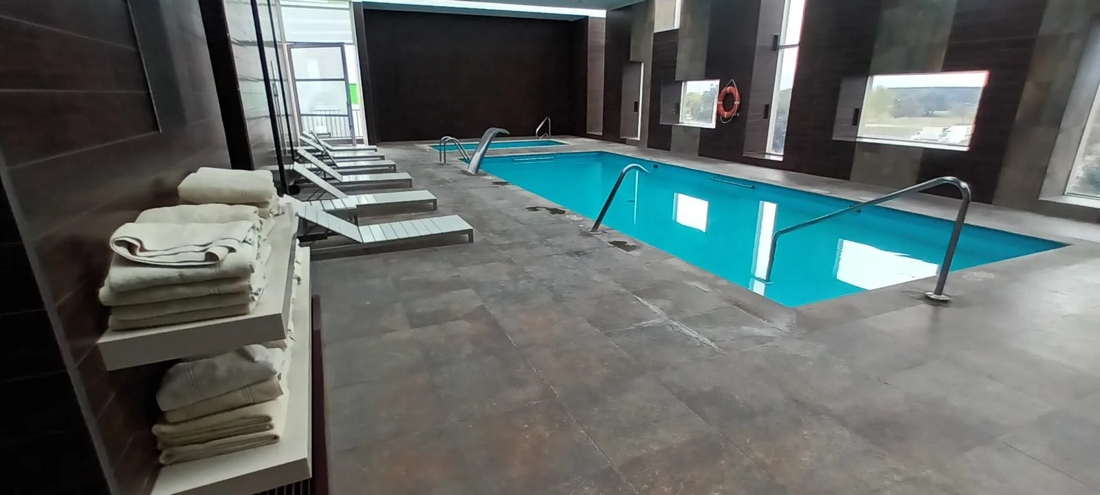 Indoor-Pool mit Liegen und Handtüchern