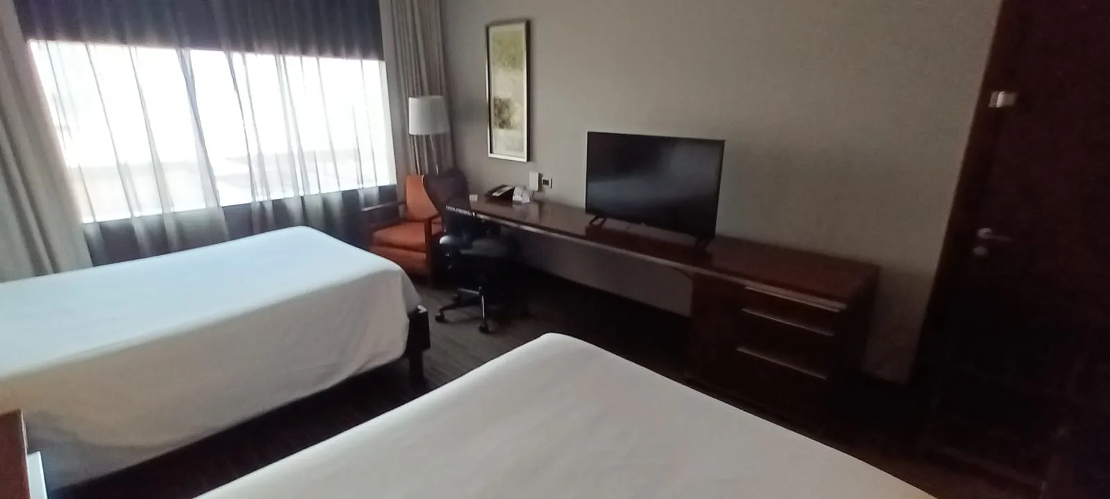 Hotelzimmer mit Doppelbetten und Flachbildfernseher