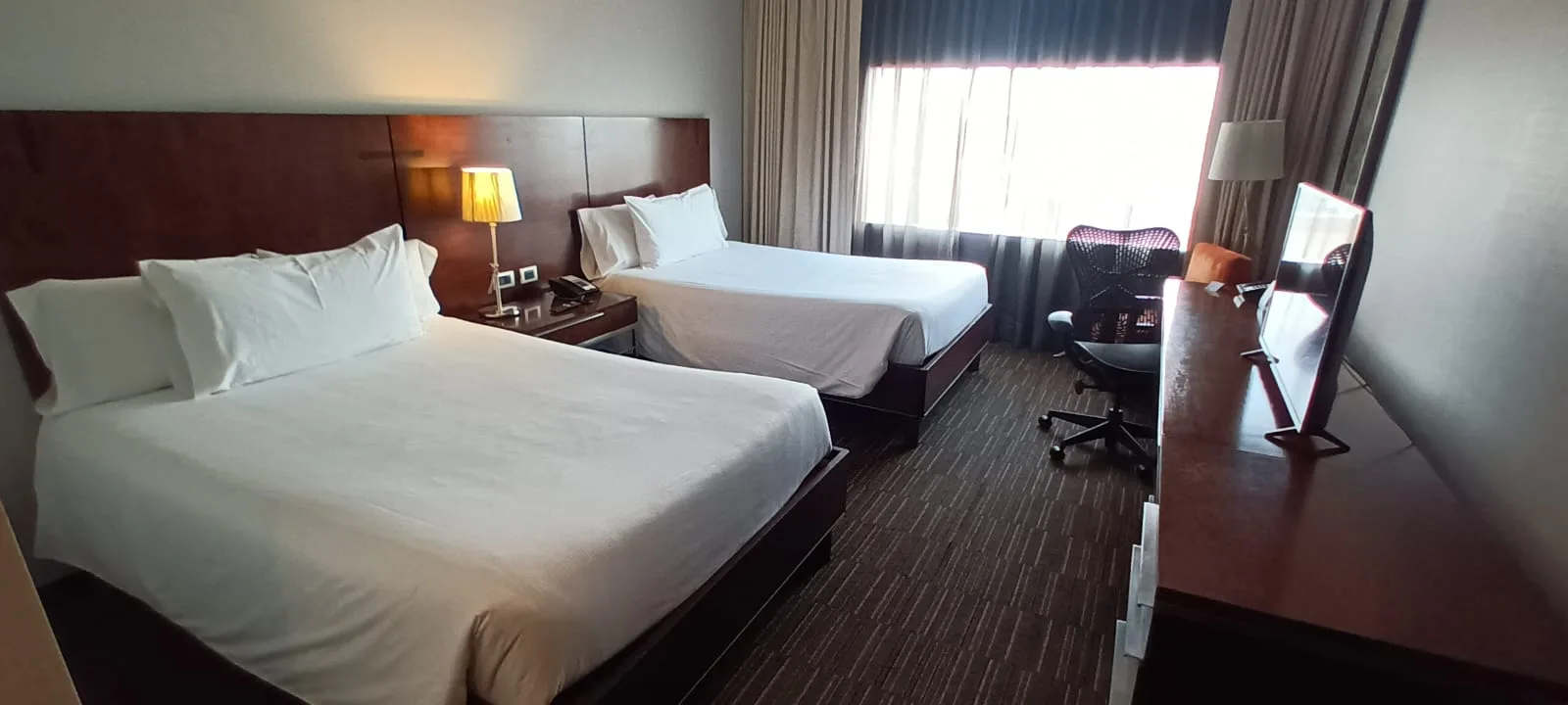 Hotelzimmer mit zwei Einzelbetten und Schreibtisch
