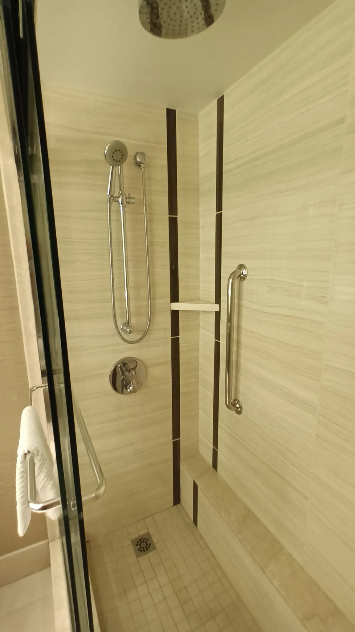 Duschbereich mit Handtuchhalter und Regal im King Sky View Zimmer