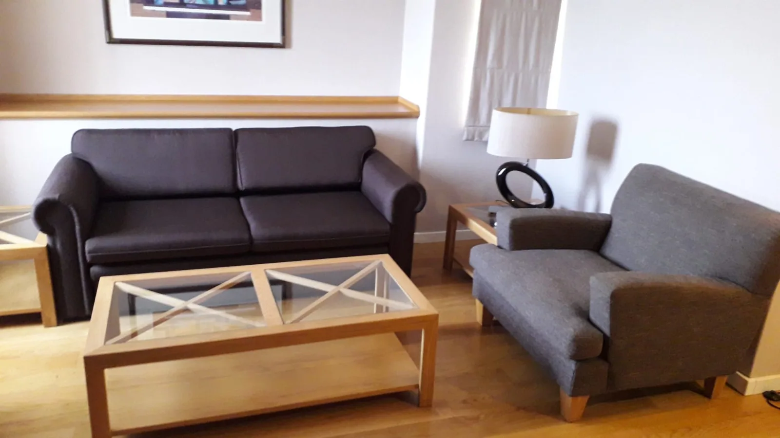 Hotelzimmer mit Couch und Sessel in Grautönen