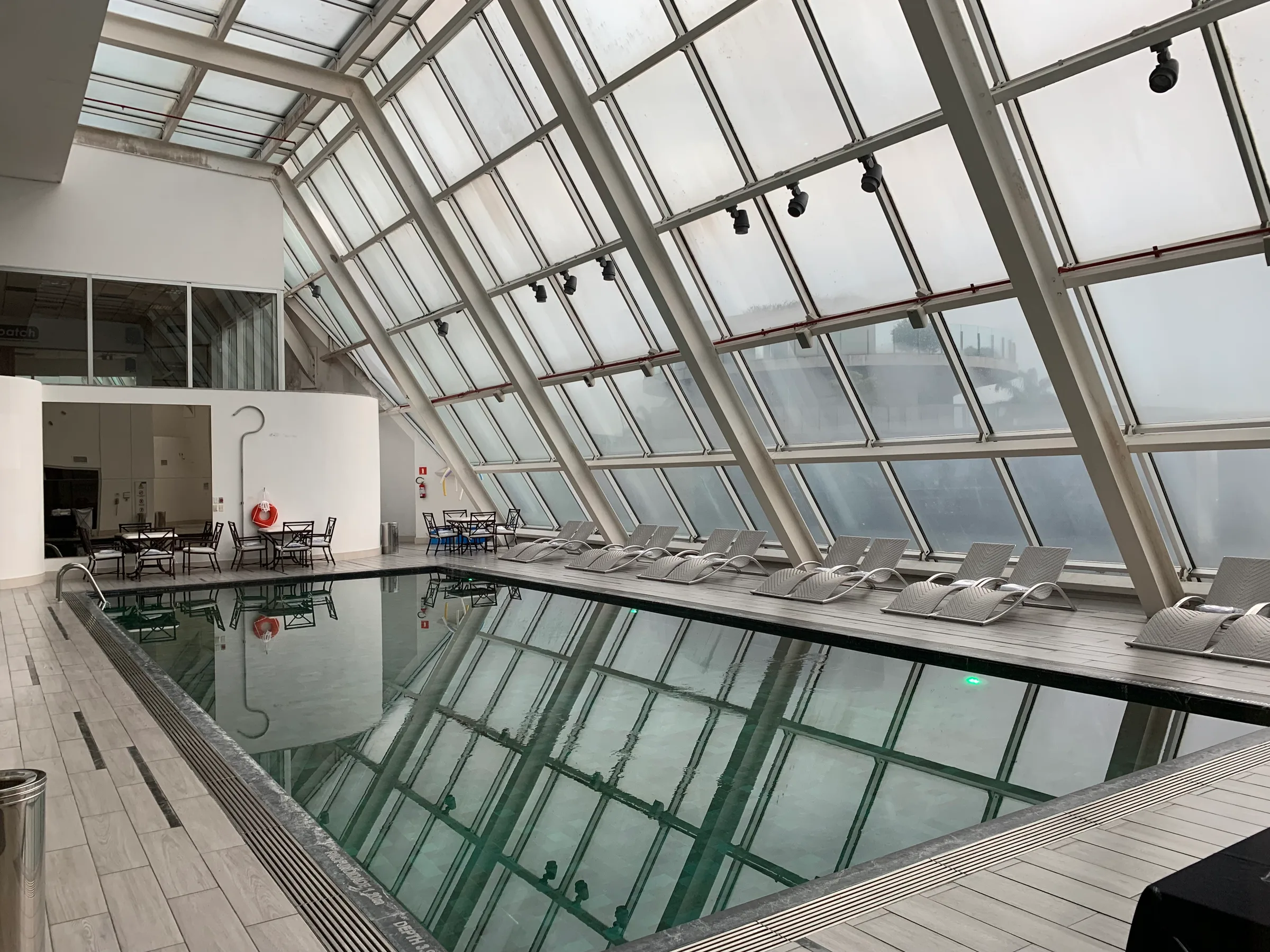 Innenansicht eines Hotels mit Glasdach und Pool