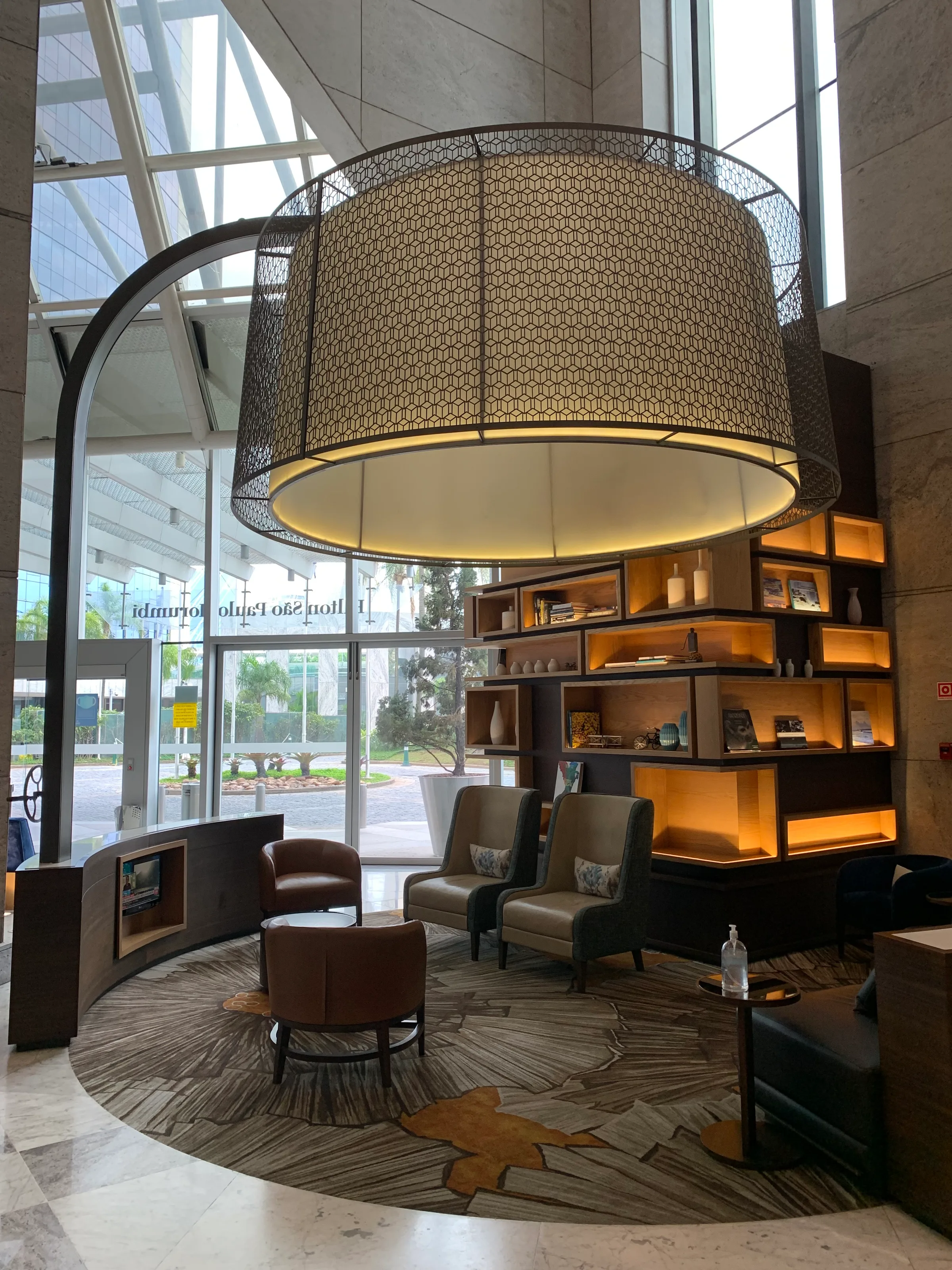 Lobbybereich eines Hotels mit Sesseln und Bücherregal