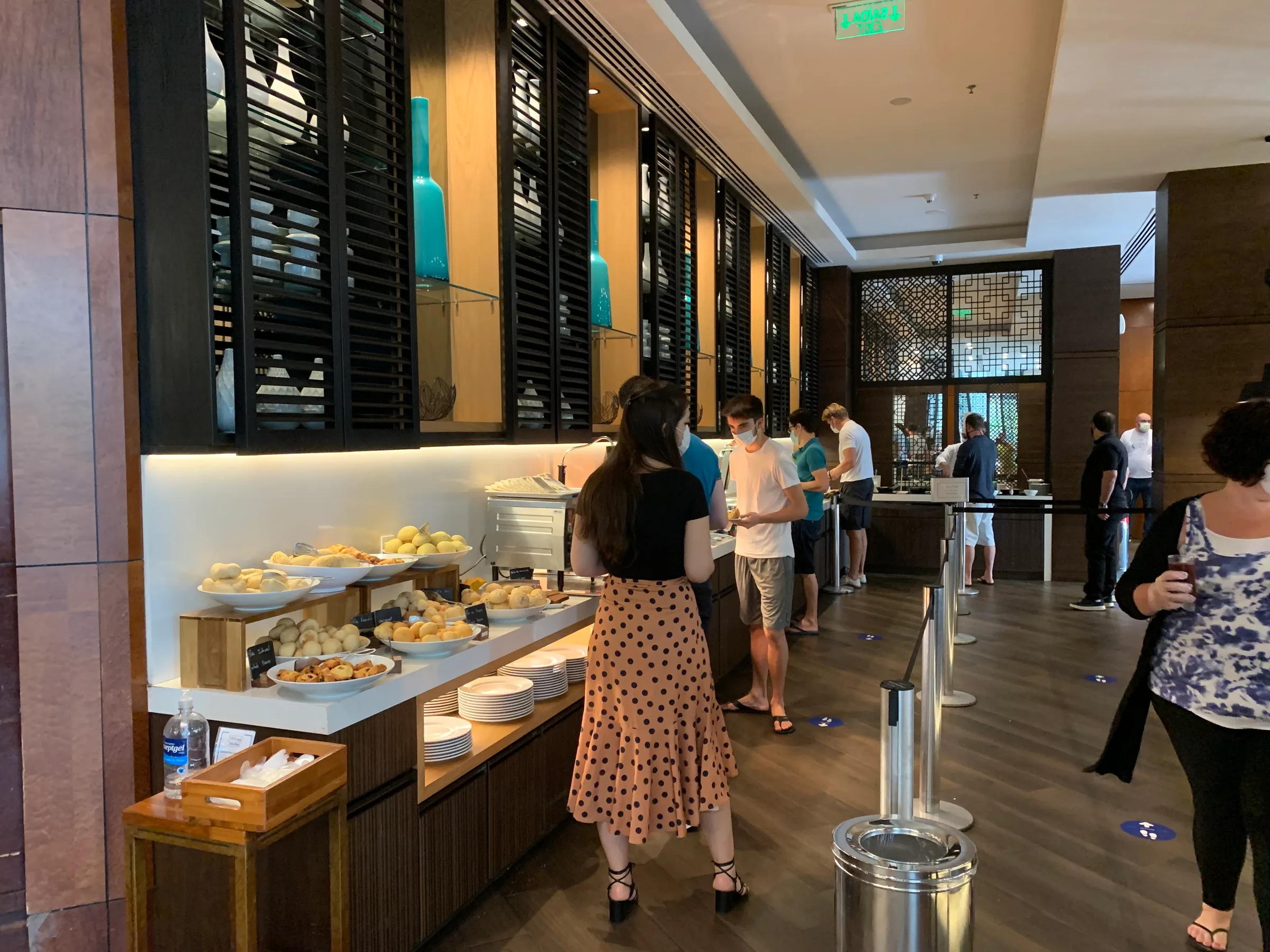 Hotellobby mit Buffet und Menschen in Masken