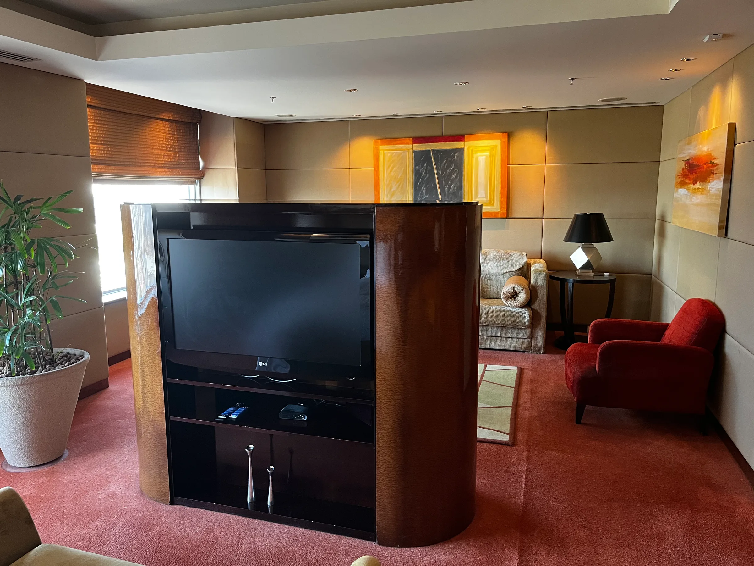Hotelzimmer mit Fernseher und rotem Sessel