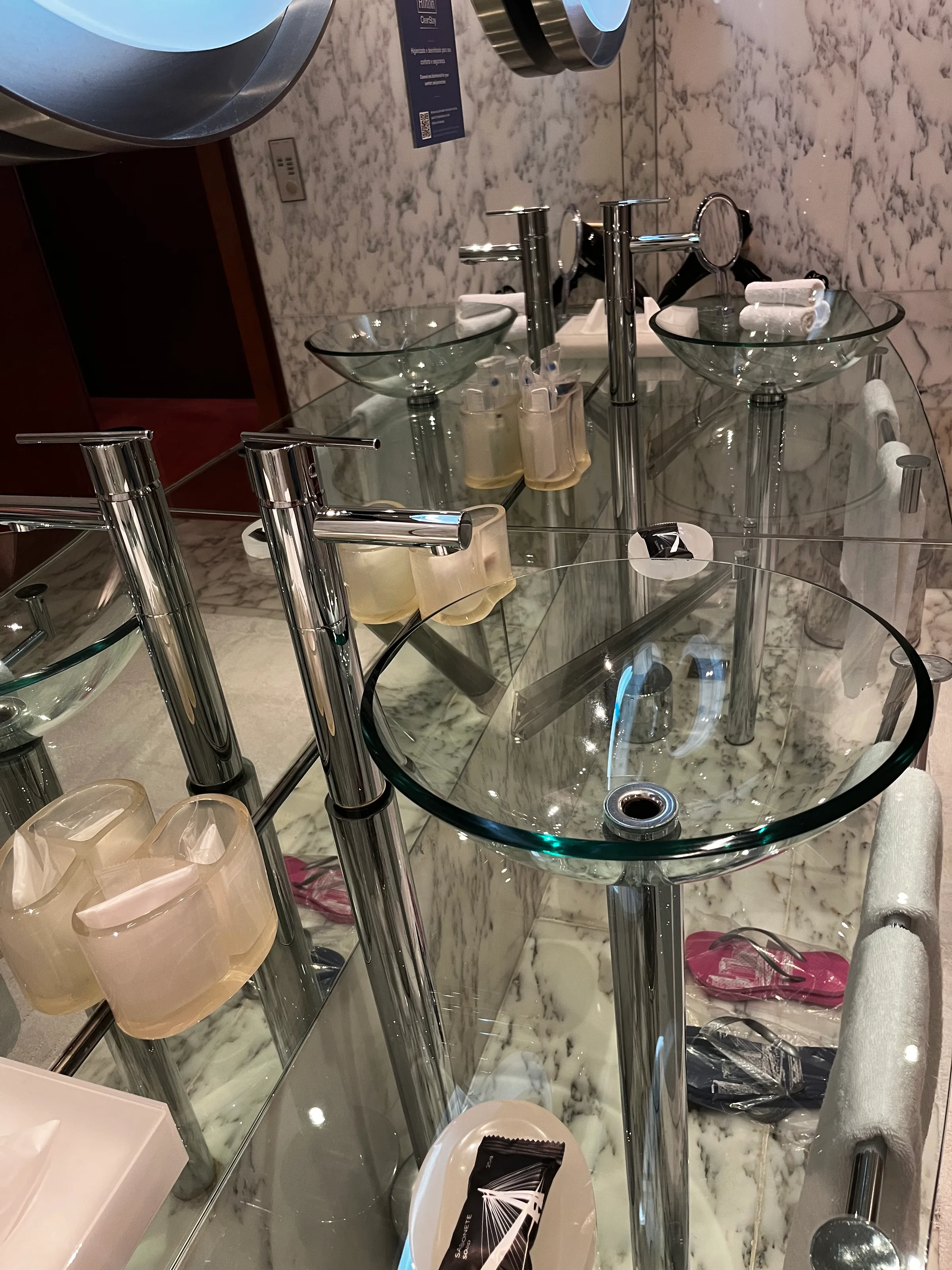 Doppelwaschtisch mit Glasbecken und Chromarmaturen im Badezimmer