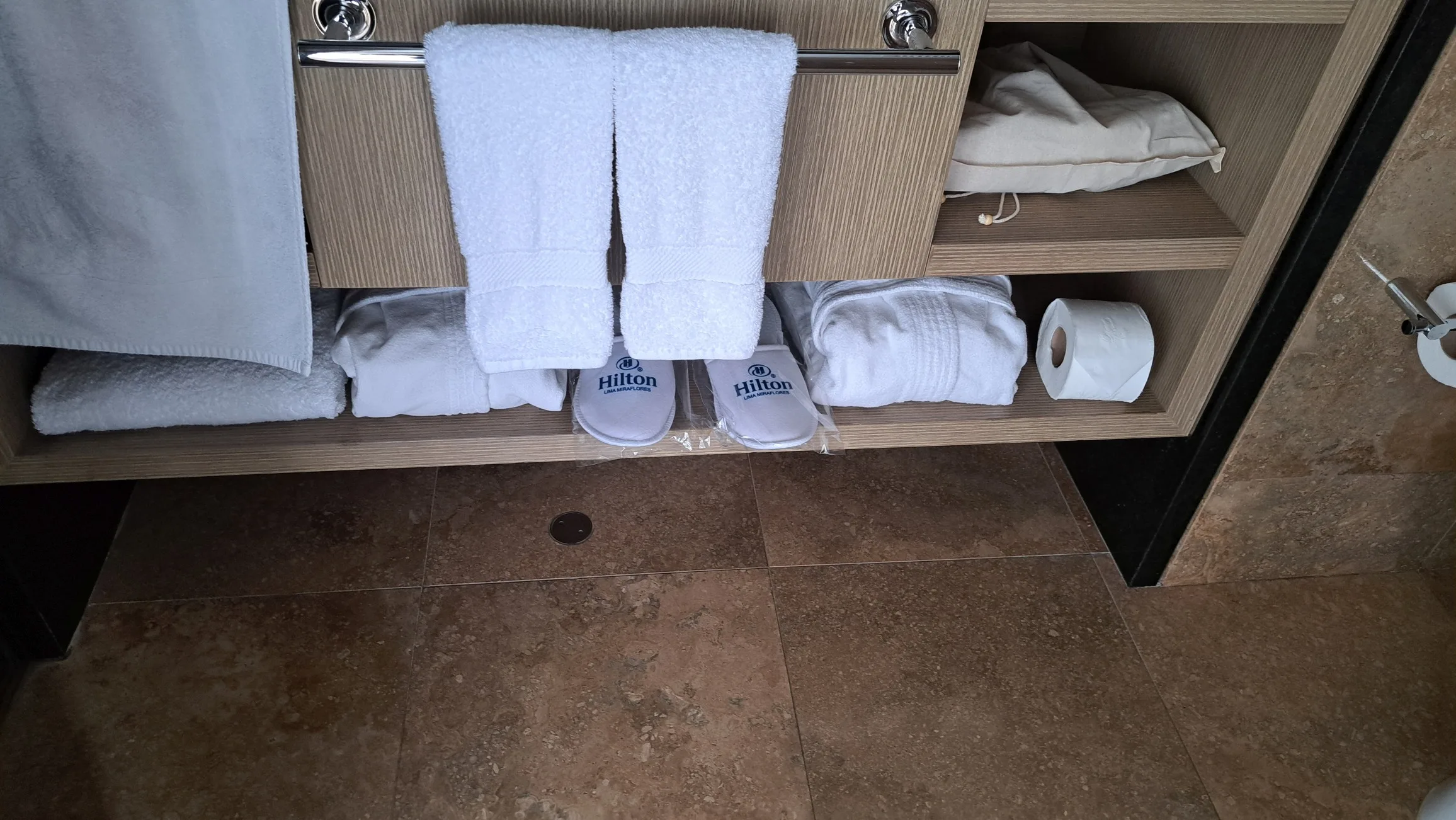 Schrank mit Handtüchern, Hausschuhen und Bademantel