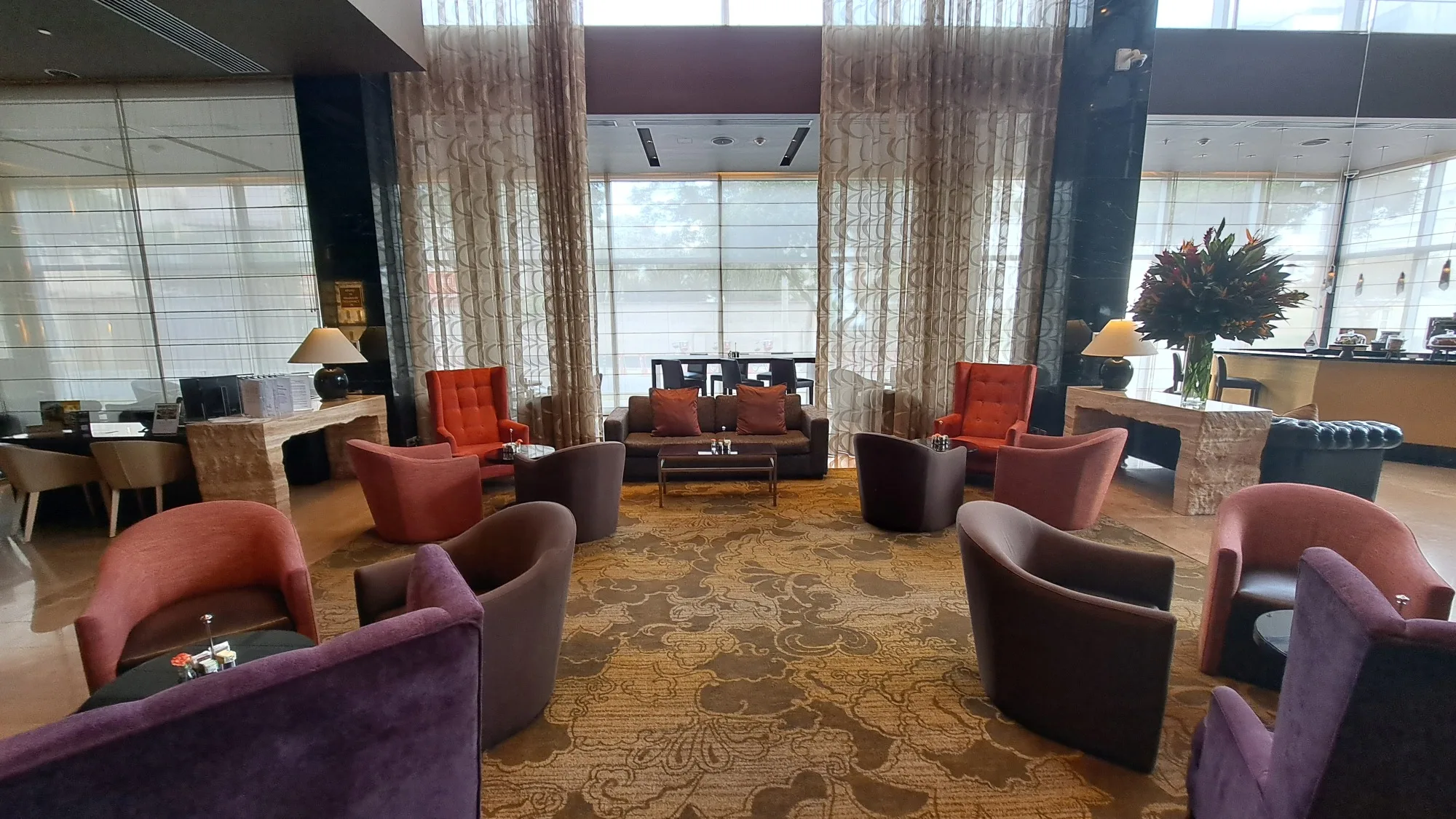 Hotellobby mit Sesseln und Couchen in warmen Farben