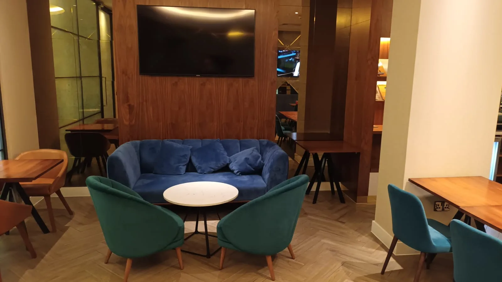 Hotellobby mit blauem Sofa und grünen Stühlen