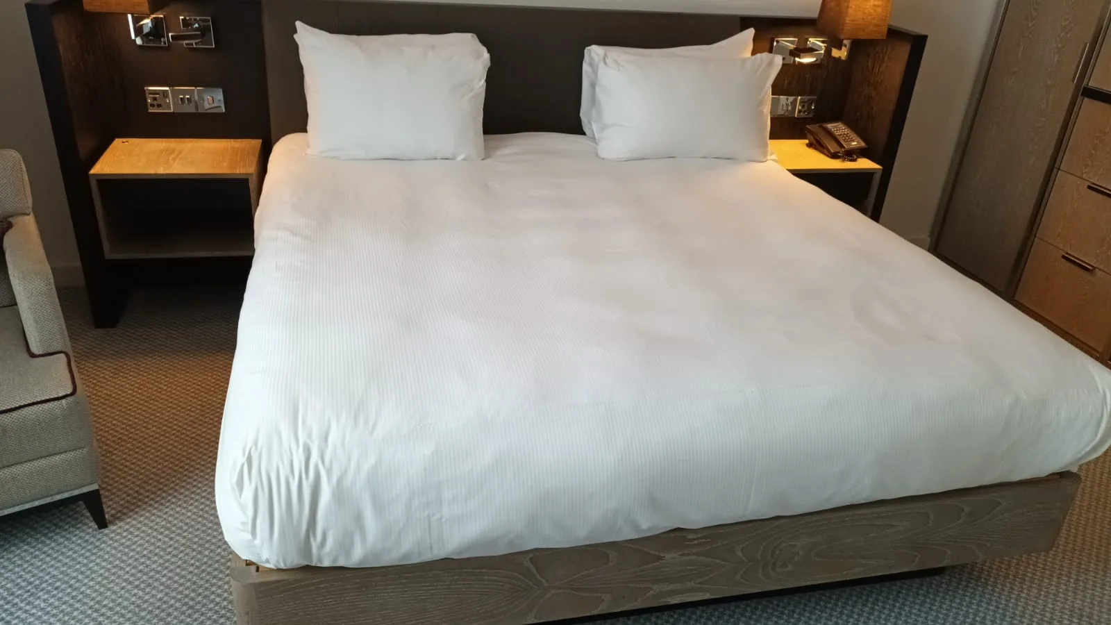 Doppelbett im Hotelzimmer mit grauem Laken