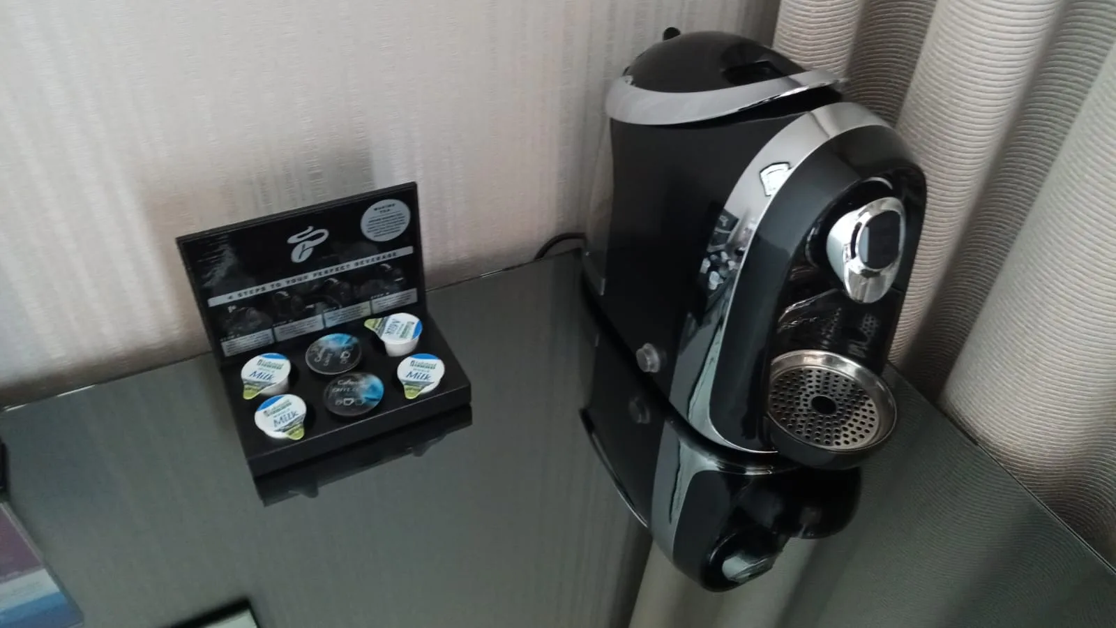 Kaffeemaschine und Kapseln auf Nachttisch