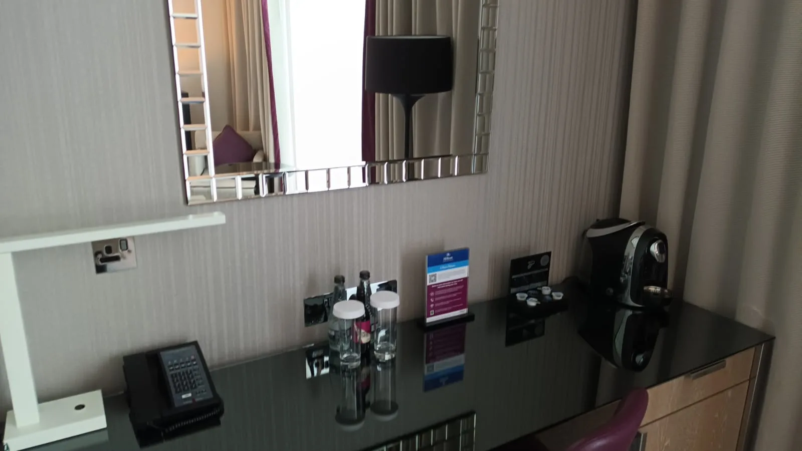 Hotelzimmerschreibtisch mit Kaffeemaschine und Getränkeflaschen