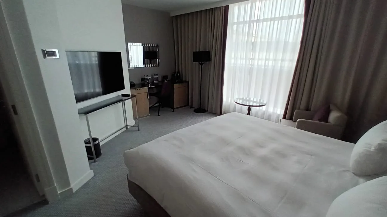Hotelzimmer mit Doppelbett und grauem Tagesdeckenbesatz