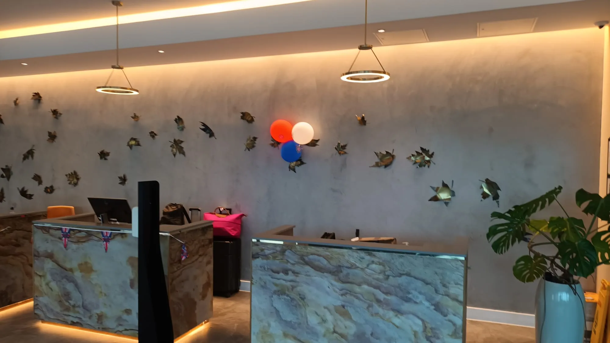 Rezeption mit Marmor-Design und Blumenkranz an der Wand
