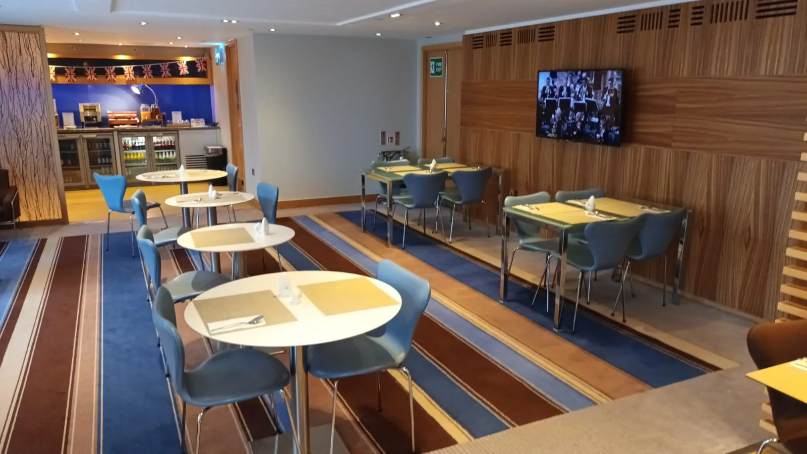 Hotelrestaurant mit runden Tischen und blauen Stühlen