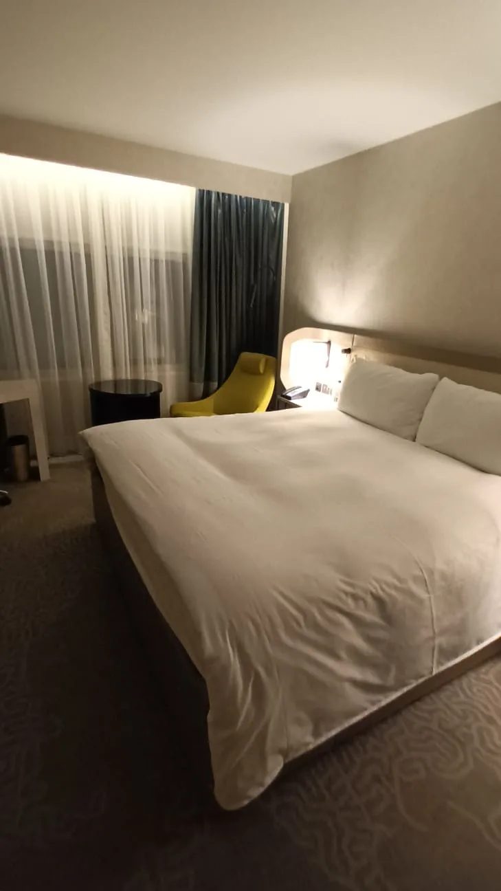 Hotelzimmer mit Doppelbett und Nachttisch