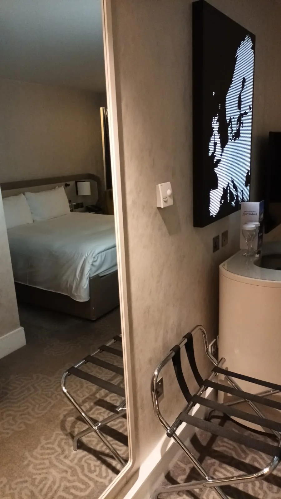 Hotelzimmer mit Doppelbett und Weltkarte an der Wand