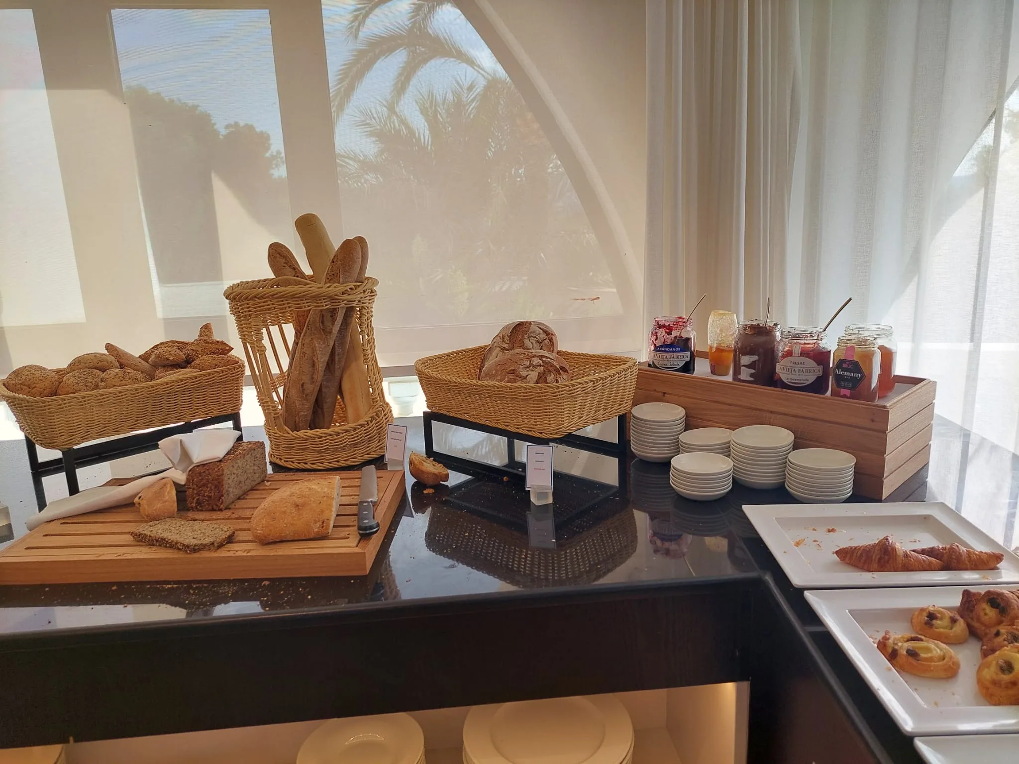 Frühstückstisch mit Brotkörben und Marmeladen im Hotel